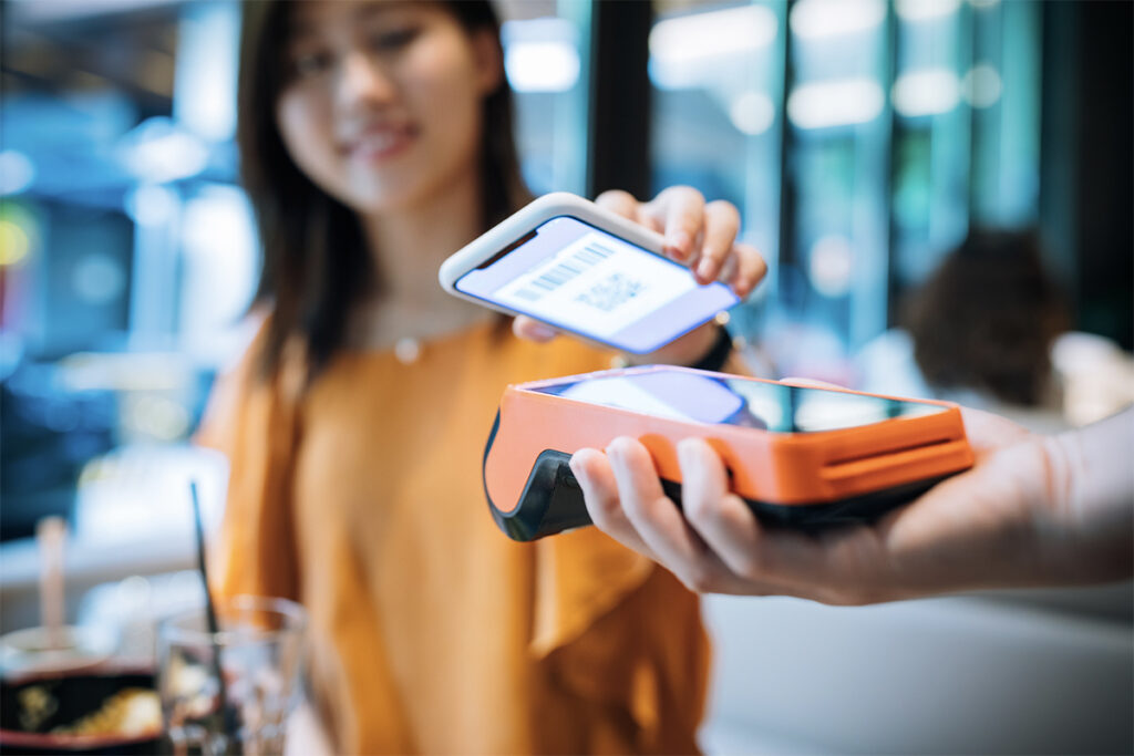 Woman using her phone as digital payment at a store.