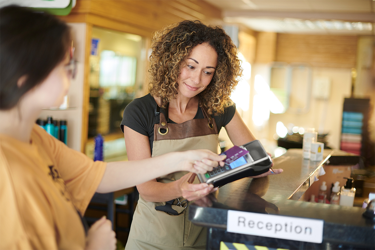 Customer using her digital card to checkout at a store.