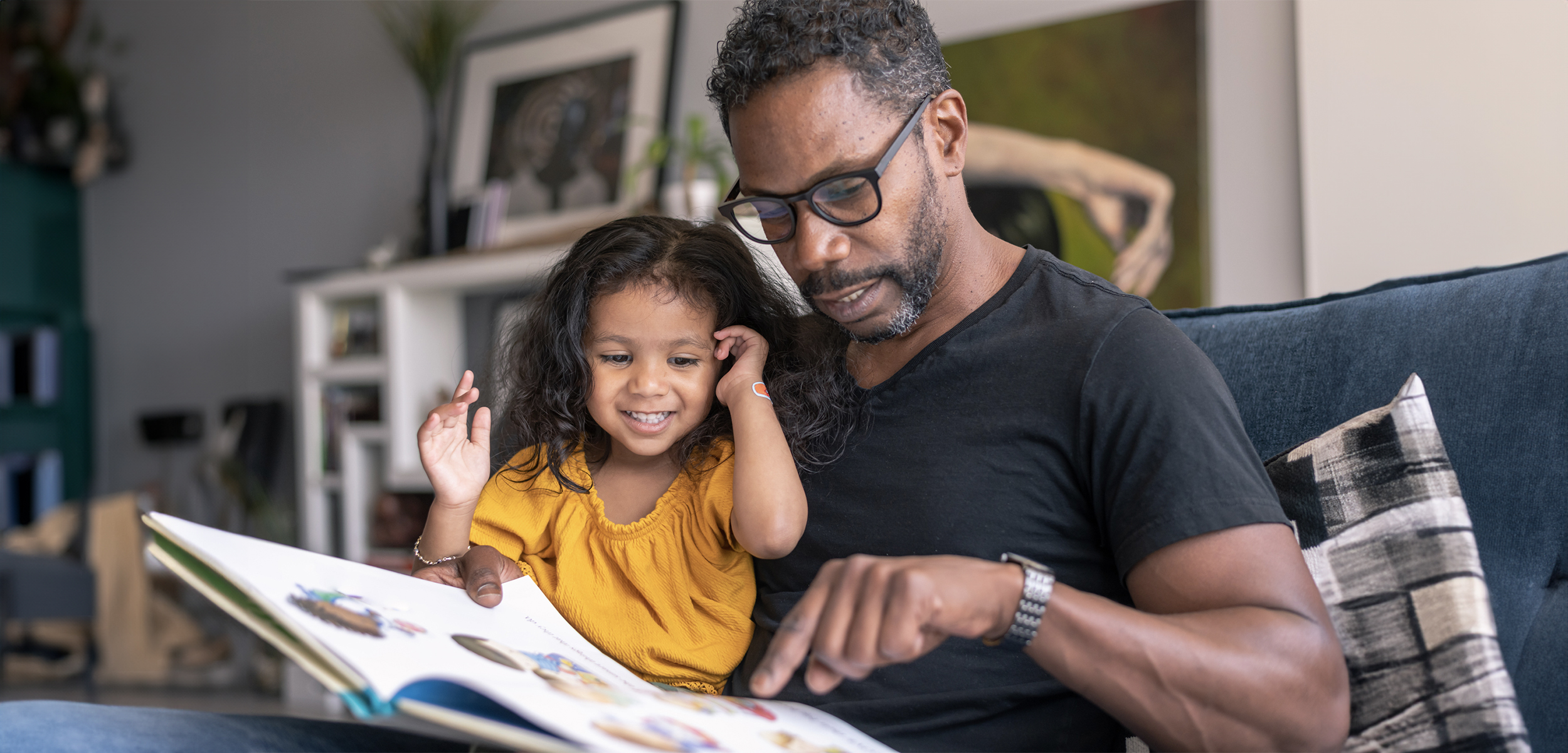 A father teaching his daughter how to read.