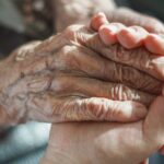 Adult child holding an elderly parent’s hands