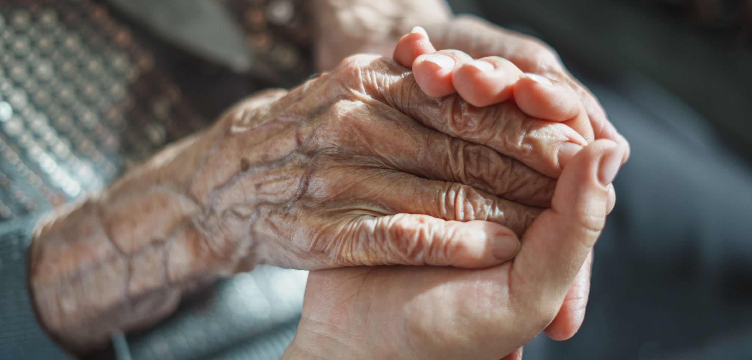 Adult child holding an elderly parent’s hands