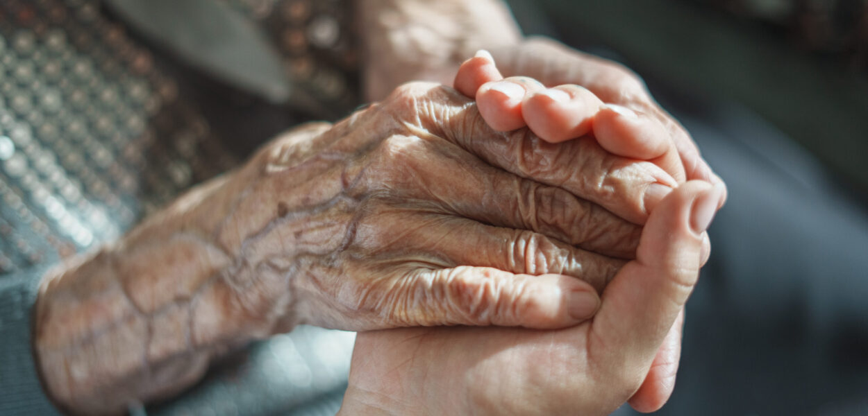 Three generations hand in hands Adult child holding an elderly parent’s hands